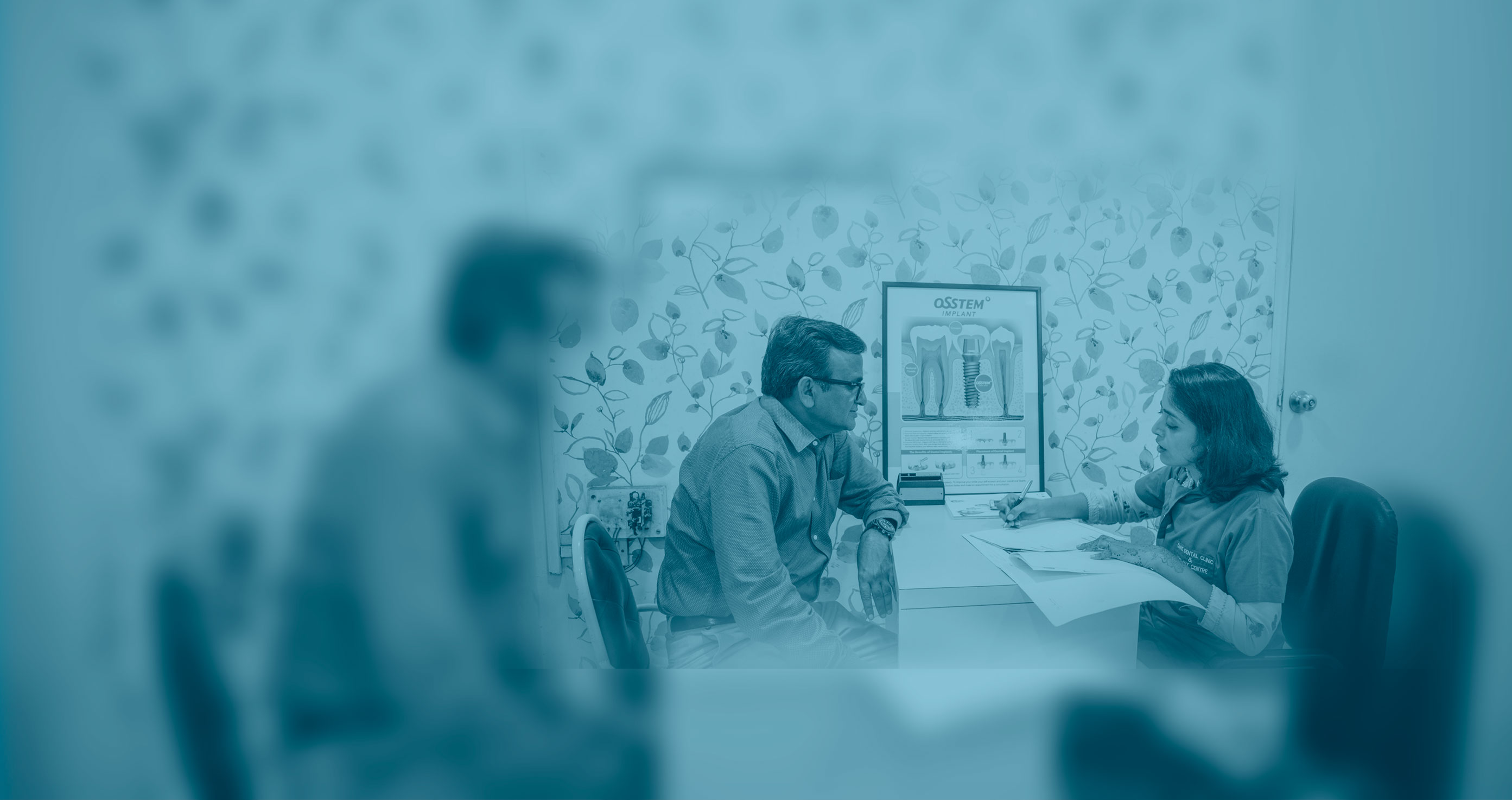 Two people in an office, engaged in a conversation at a table
      