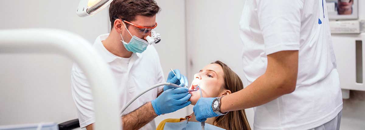 A dentist carefully examining a patient's teeth to ensure their oral health and provide necessary with painless dental treatment.